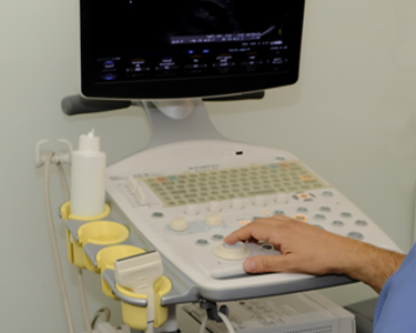 Handsome male doctor near ultrasound scanner machine